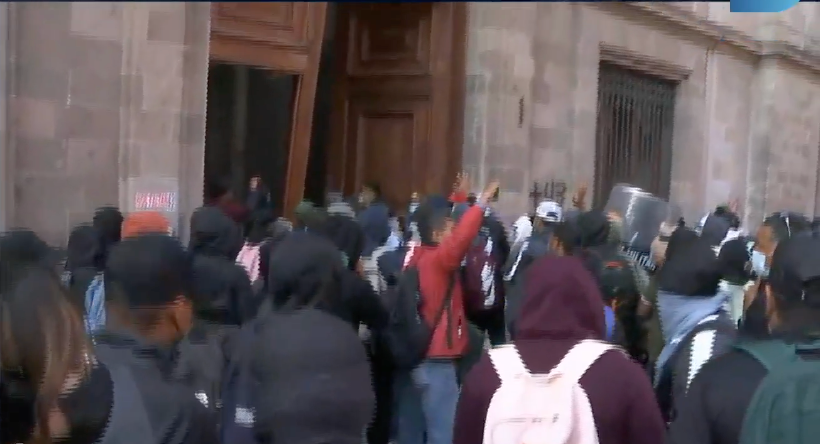 Normalistas de Ayotzinapa derriban una puerta para ingresar a Palacio Nacional