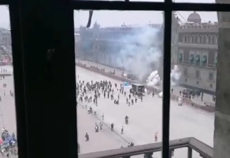 Normalistas de Ayotzinapa lanzan cohetes a fachada de Palacio Nacional